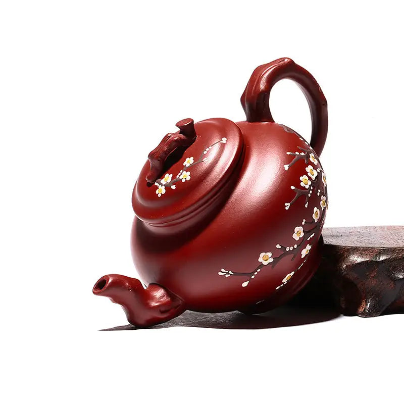 Reddish-brown Yixing teapot with hand-painted plum blossoms in authentic Zisha clay