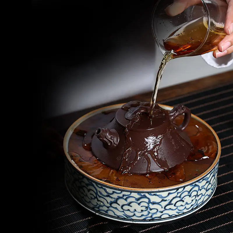 Brown Yixing Zisha teapot with dragon spout being rinsed, part of Wishful Dragon collection