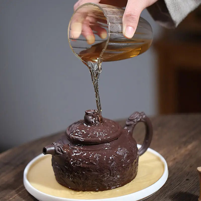 Wishful Dragon Yixing Zisha purple clay teapot being filled with hot water