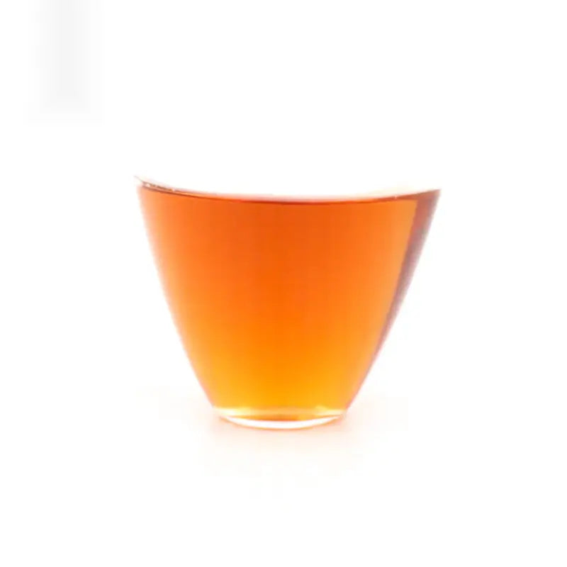 Amber liquid in a clear glass of Wuyi Rougui rock tea with traditional roasting process