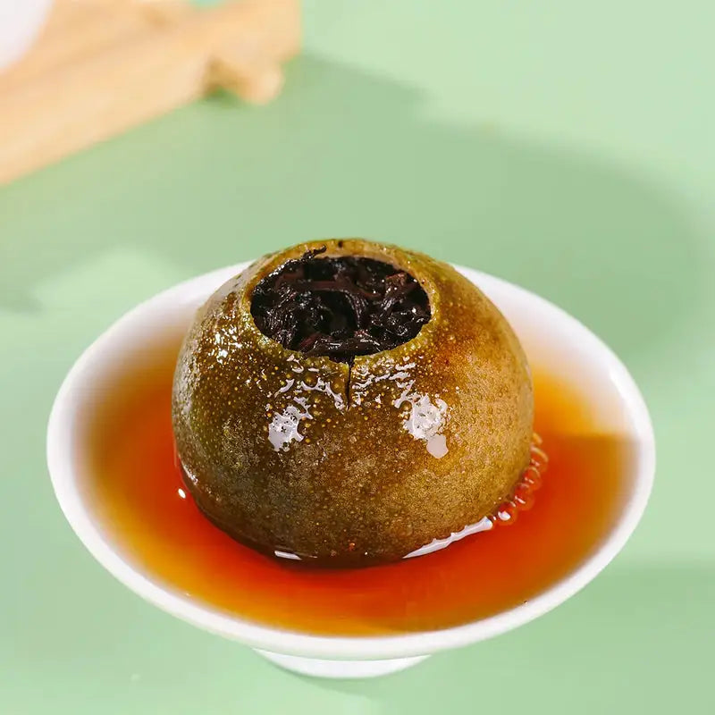 Citrus fruit filled with dark tea in Xiao Qing Gan Pu’er Tea Leave for teapots and tea sets