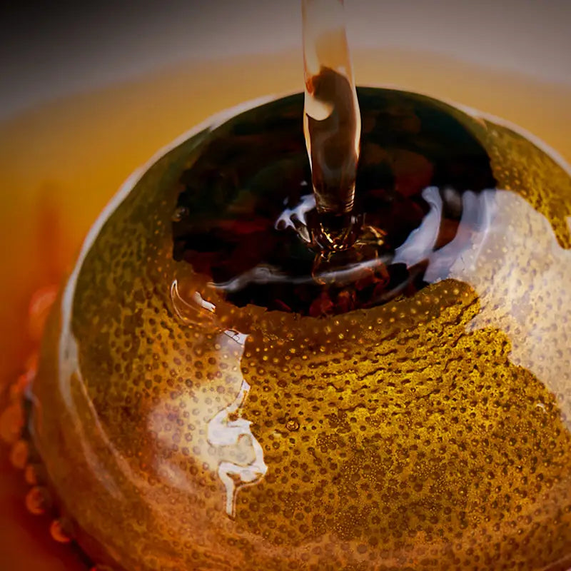 Peeled orange filled with liquid featuring Xiao Qing Gan Pu’er Tea Leaves and tea sets