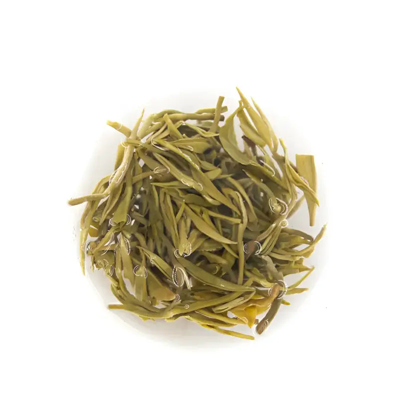 Pile of Yunnan Spring Green Tea leaves with orchid fragrance and bright liquor displays natural quality